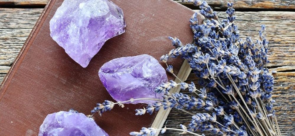 Raw amethyst crystals and dried lavender on an old book