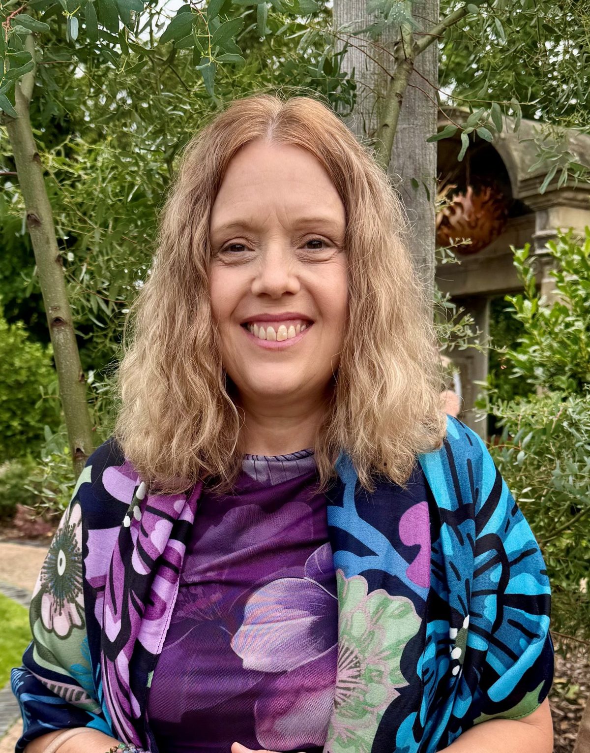Liz Allan, founder of Inner Wisdom, smiling in a garden