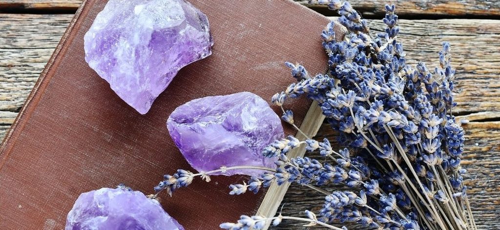 Amethyst crystals and dried lavender on a wooden table.